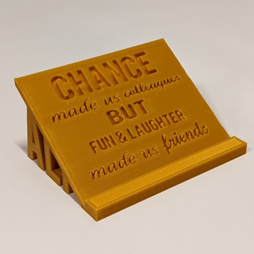 gold 3d printed plaque that reads "chance made us collegues but fun and laughter made us friends"